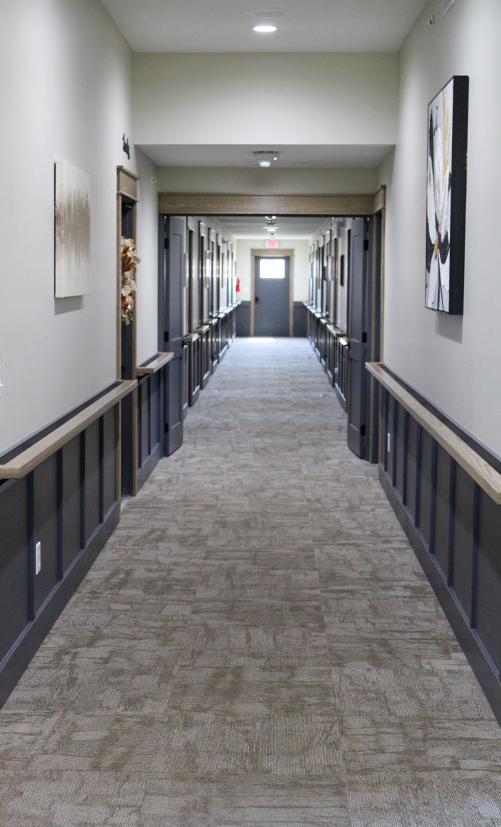 A wide, carpeted hallway with artwork