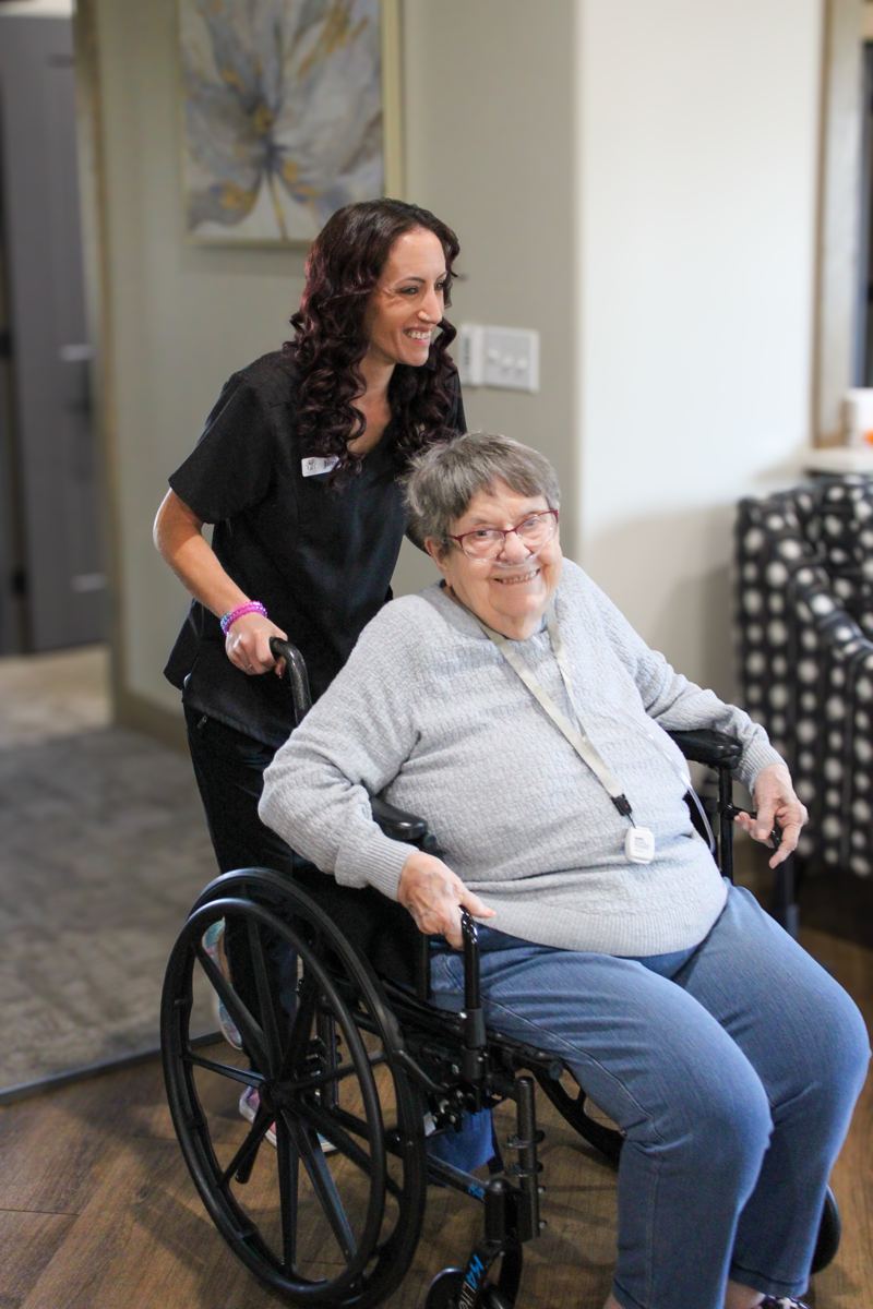A staff member with a resident in the lounge