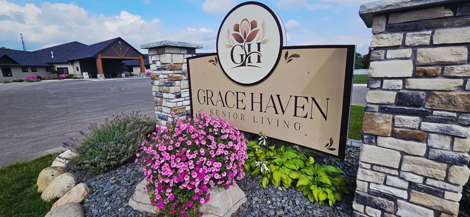 The Grace Haven Senior Living stone sign with pink petunias